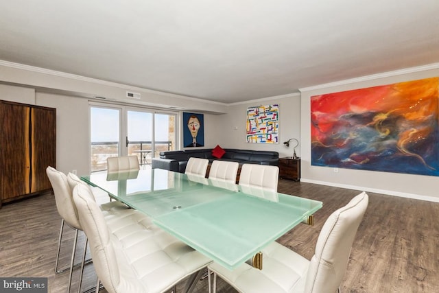 dining room with baseboards, crown molding, visible vents, and wood finished floors