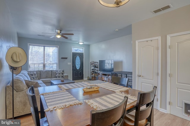 dining area with light wood-style flooring, visible vents, ceiling fan, and baseboards