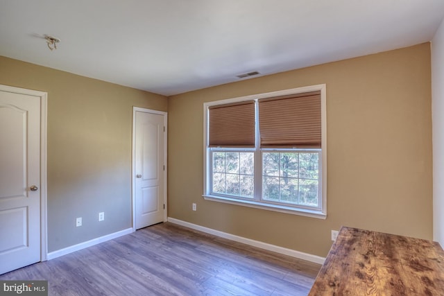 interior space with visible vents, baseboards, and wood finished floors