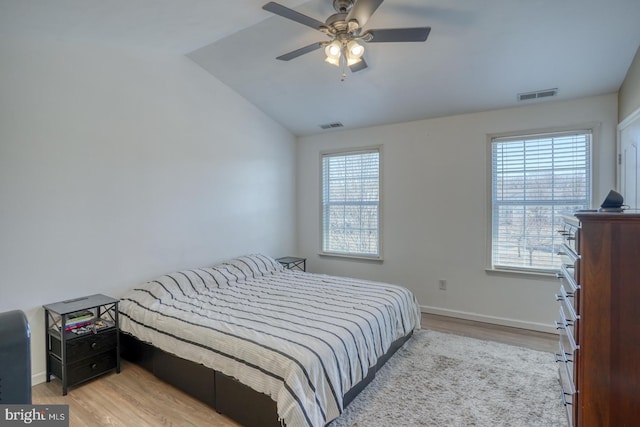 bedroom featuring baseboards, visible vents, and wood finished floors