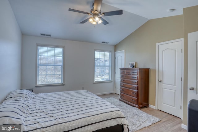 bedroom featuring vaulted ceiling, light wood-type flooring, visible vents, and baseboards