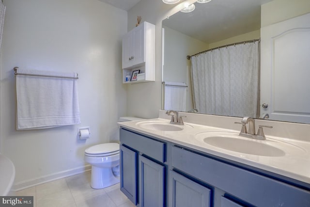 full bath with toilet, double vanity, a sink, and tile patterned floors