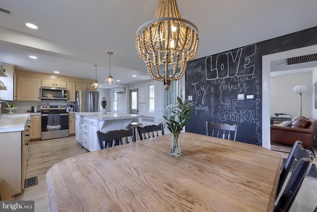 dining area featuring light wood-style floors, recessed lighting, visible vents, and an inviting chandelier