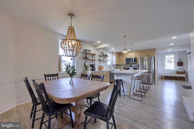 dining space with a wainscoted wall, recessed lighting, a notable chandelier, and light wood-style floors