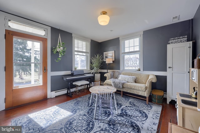 living room featuring a wealth of natural light, visible vents, and hardwood / wood-style floors