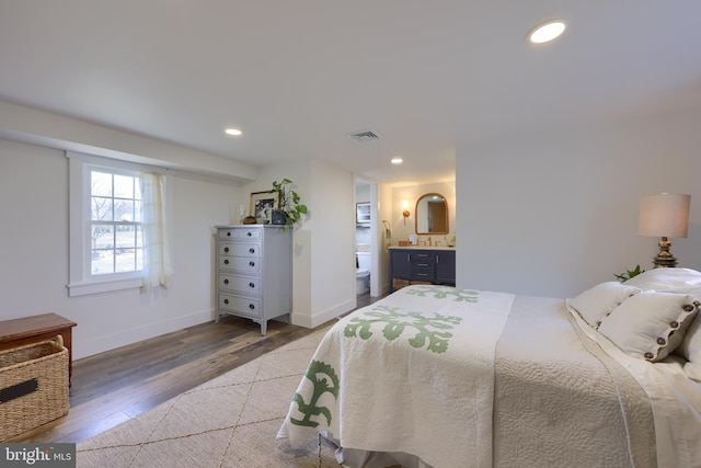 bedroom featuring baseboards, wood finished floors, and recessed lighting