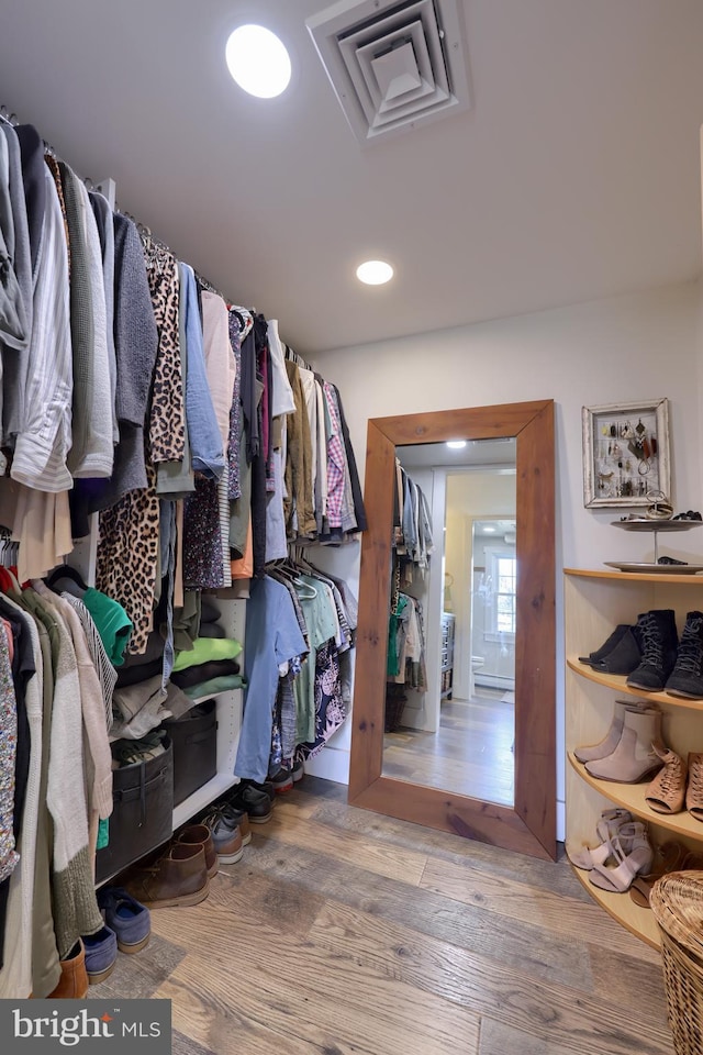 walk in closet with visible vents and wood finished floors