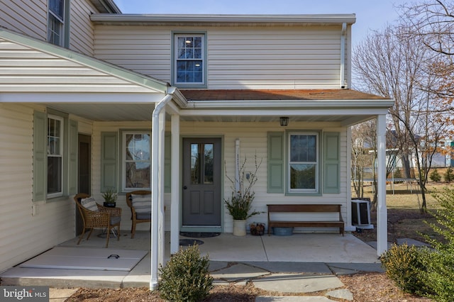 doorway to property featuring a porch and central air condition unit