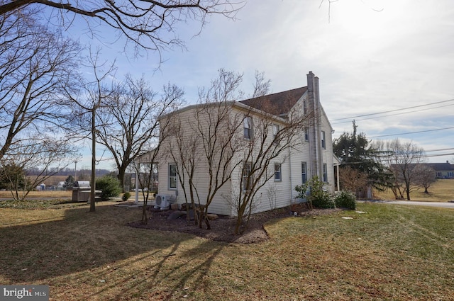 view of home's exterior featuring a lawn and a chimney