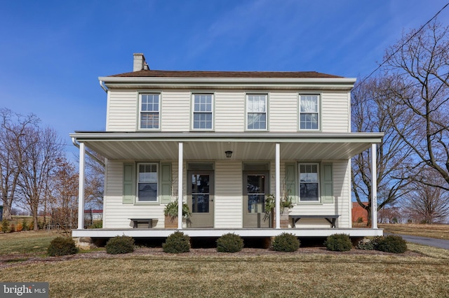 view of front of property featuring a chimney, a front lawn, and a porch