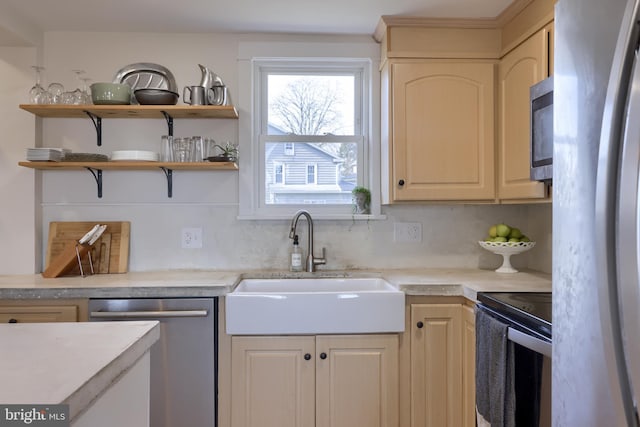 kitchen with decorative backsplash, appliances with stainless steel finishes, light countertops, and a sink