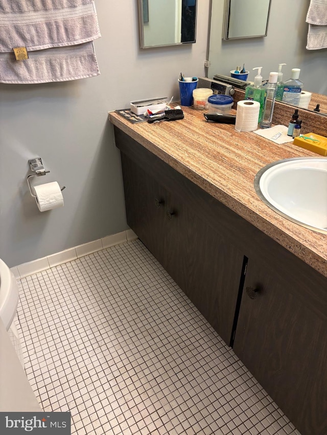 bathroom with baseboards, vanity, and tile patterned floors