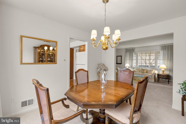 dining room with a chandelier, carpet, and visible vents