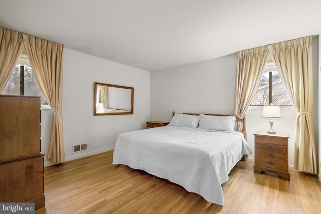 bedroom featuring light wood-type flooring, baseboards, and visible vents