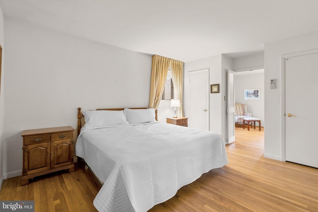 bedroom with light wood-style flooring and baseboards