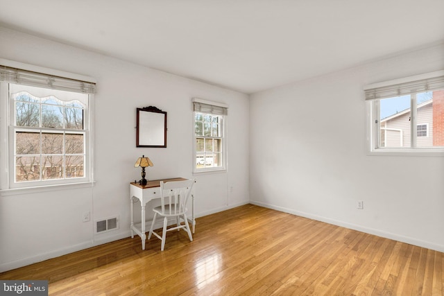 interior space featuring light wood-style floors, visible vents, and baseboards