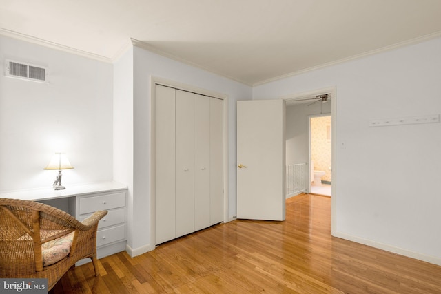 sitting room with light wood-type flooring, baseboards, visible vents, and crown molding