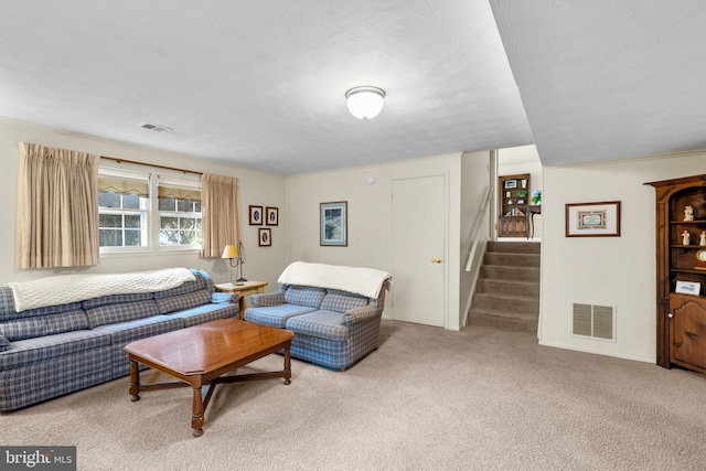 living area with stairway, carpet, and visible vents