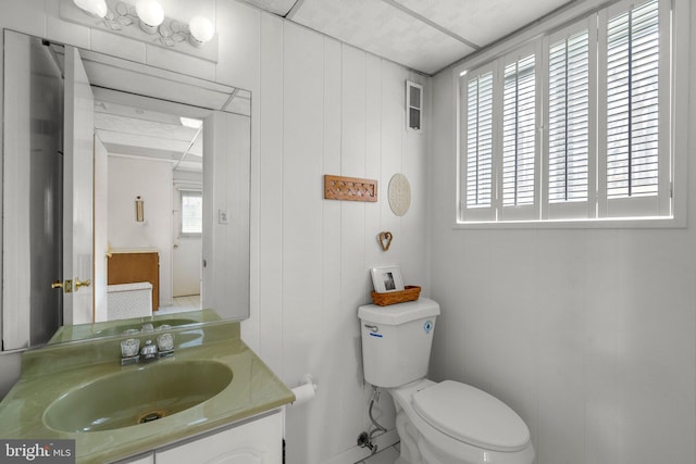 half bathroom with toilet, visible vents, and vanity