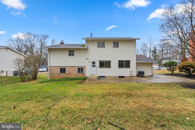 rear view of property featuring entry steps, a patio, central AC unit, a yard, and a chimney