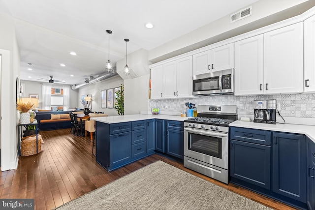 kitchen featuring visible vents, appliances with stainless steel finishes, blue cabinets, a peninsula, and white cabinetry