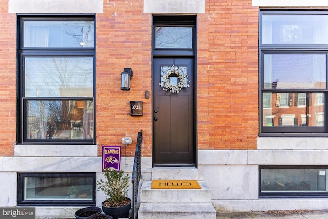 view of exterior entry featuring brick siding