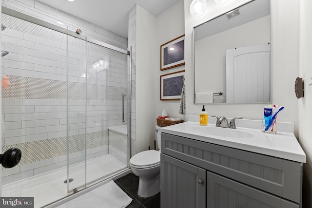 full bathroom with visible vents, toilet, a stall shower, vanity, and tile patterned flooring