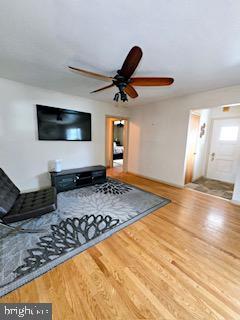 unfurnished living room with a ceiling fan and wood finished floors