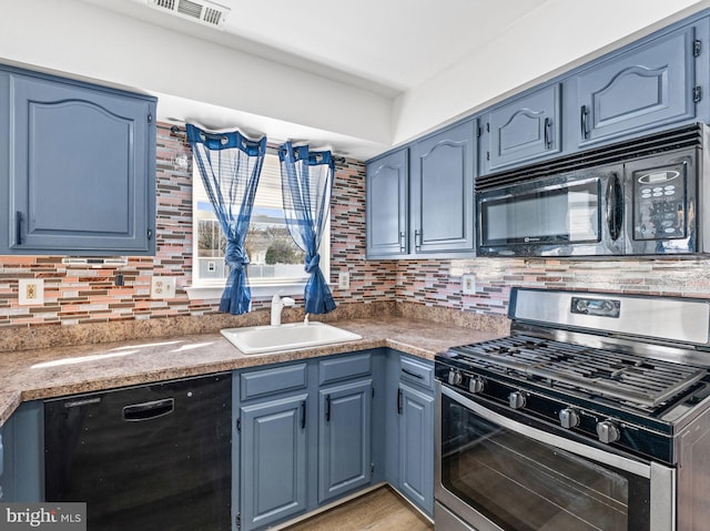 kitchen with a sink, visible vents, blue cabinetry, backsplash, and black appliances