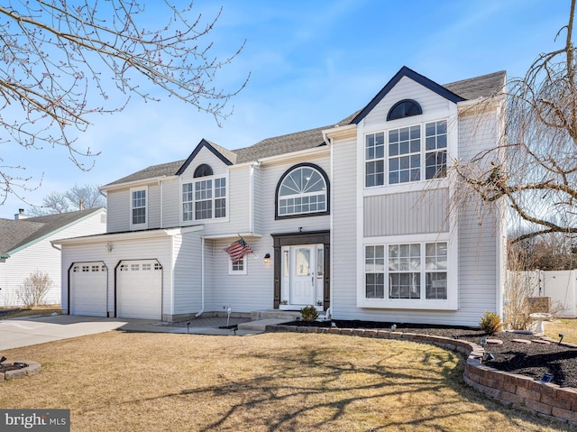 traditional home featuring driveway, fence, and a front yard