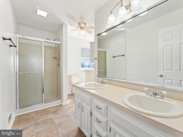 bathroom with double vanity, a shower stall, and a sink