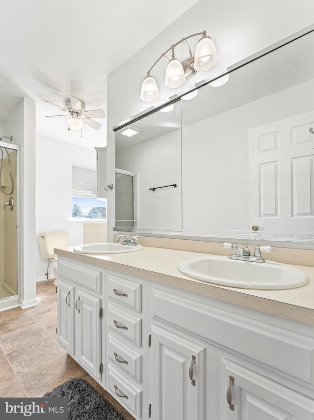 full bathroom with double vanity, a stall shower, a ceiling fan, and a sink