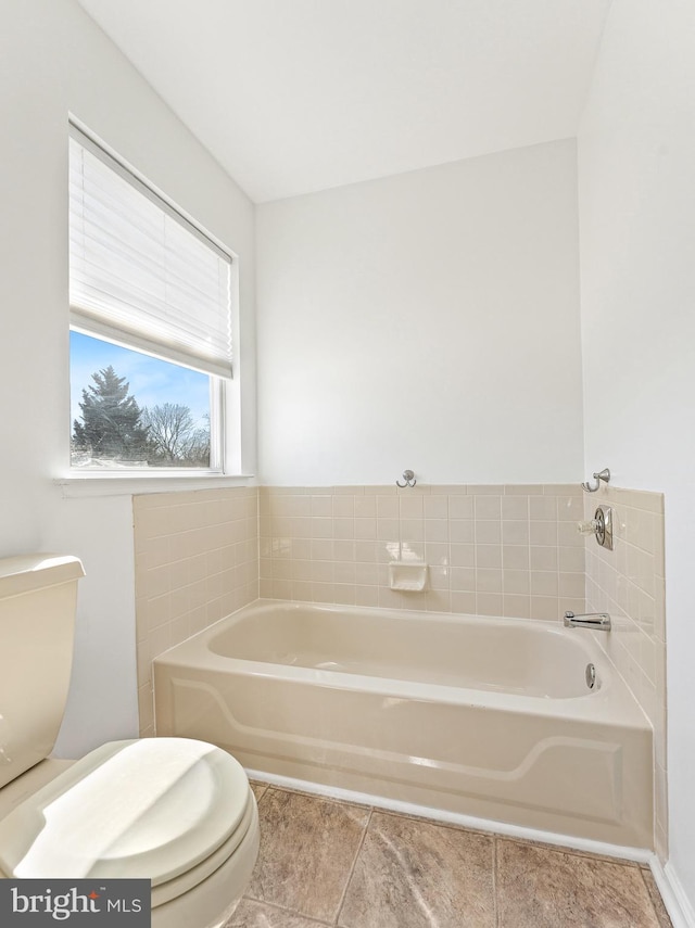 bathroom featuring a bath, toilet, and tile patterned floors