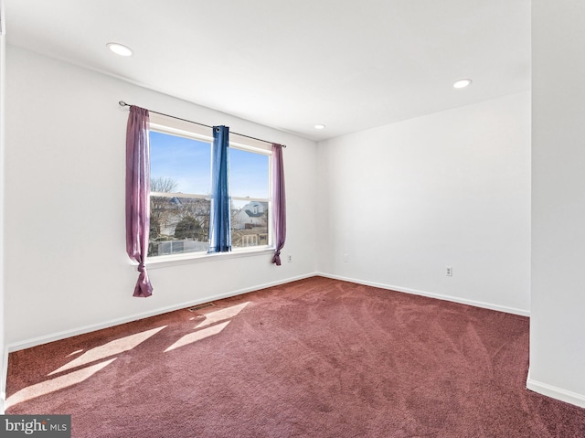 carpeted empty room with baseboards, visible vents, and recessed lighting