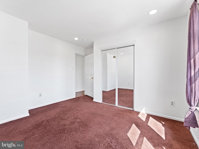 unfurnished bedroom with a closet, baseboards, carpet flooring, and recessed lighting