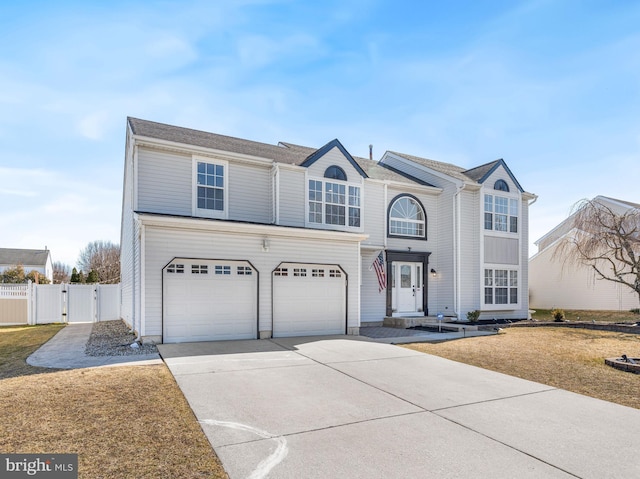 traditional-style home with concrete driveway, an attached garage, fence, and a gate