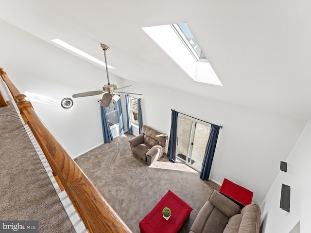 carpeted living room with vaulted ceiling with skylight