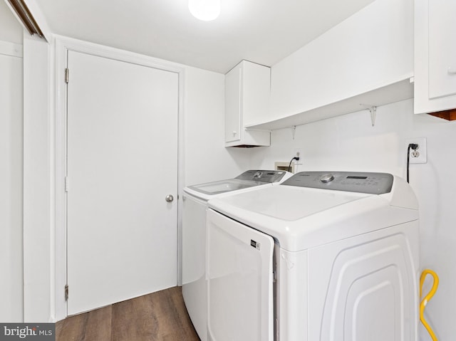 clothes washing area with washer and clothes dryer, dark wood finished floors, and cabinet space