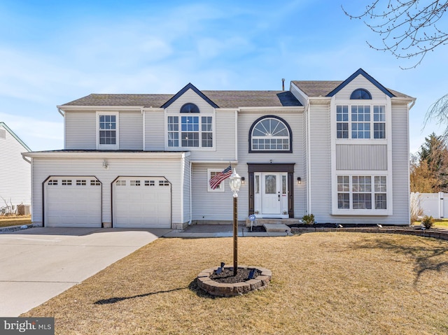 traditional-style house featuring an attached garage, a front lawn, and concrete driveway