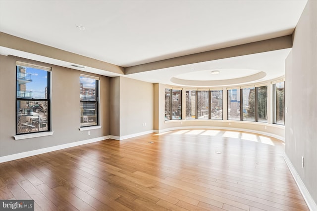 interior space with visible vents, hardwood / wood-style flooring, and baseboards