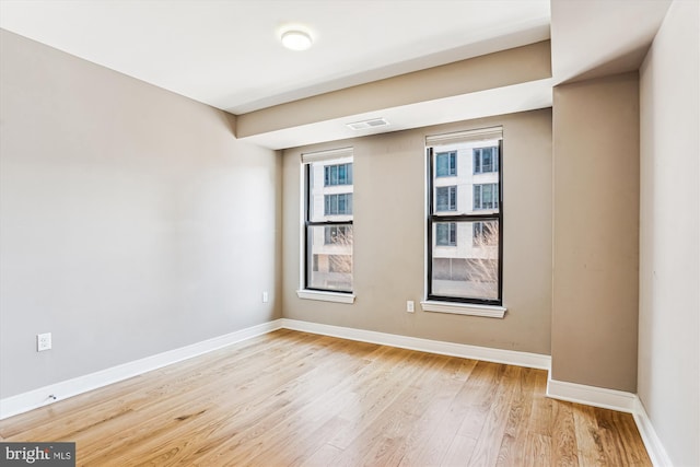 unfurnished room featuring light wood-type flooring and baseboards