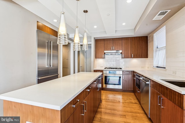 kitchen with light wood finished floors, tasteful backsplash, visible vents, stainless steel appliances, and under cabinet range hood