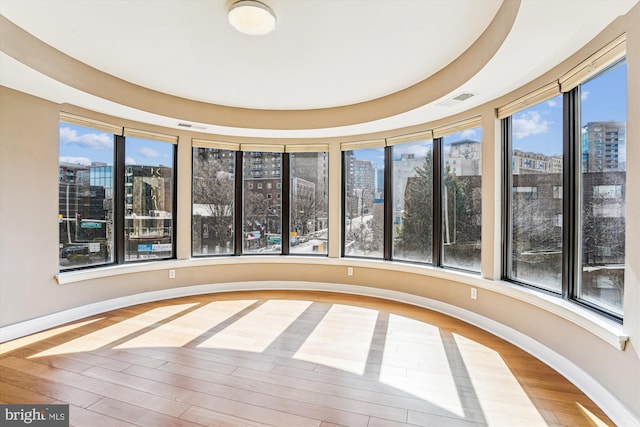 unfurnished sunroom featuring visible vents and a city view