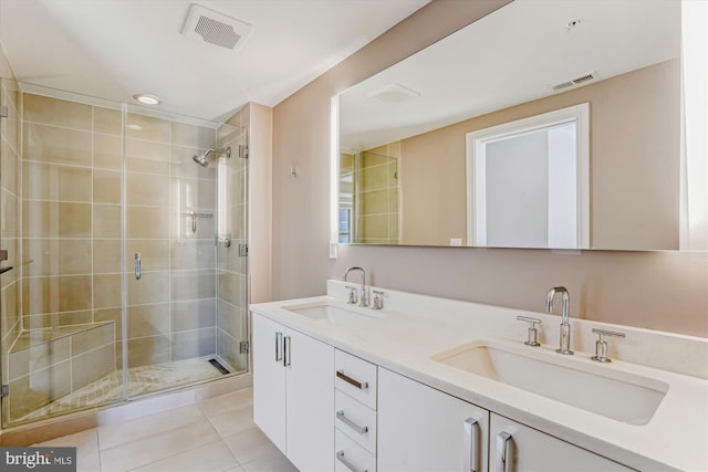 bathroom featuring a stall shower, tile patterned flooring, a sink, and visible vents