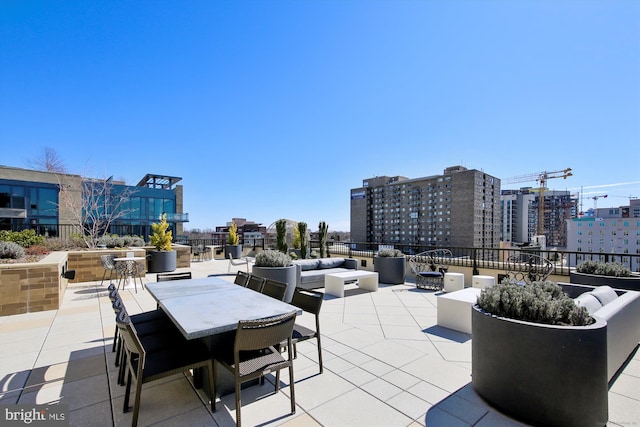 view of patio / terrace featuring a view of city, outdoor lounge area, and outdoor dining space