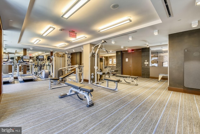 exercise room with carpet and baseboards