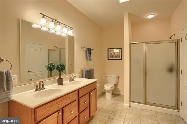 bathroom with a shower stall, a sink, and tile patterned floors