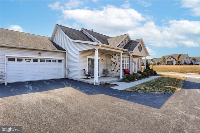 view of front facade with a garage, a shingled roof, and aphalt driveway