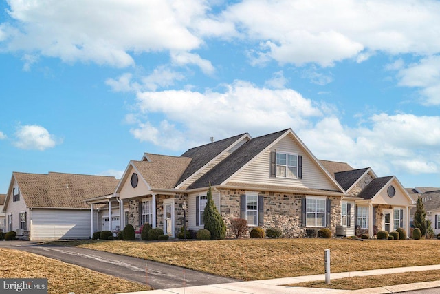 view of front facade featuring a front yard and stone siding