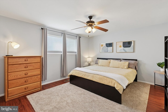 bedroom featuring ceiling fan, baseboards, and dark wood finished floors